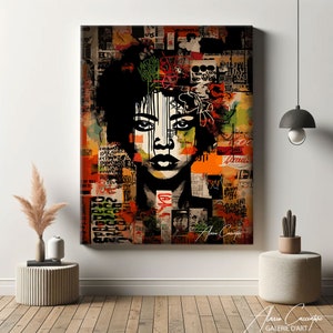 May include: A framed canvas print of a woman's portrait with a black afro and striking features. The background is a collage of text and abstract shapes in orange, green, and red. The artwork has a graffiti-style aesthetic.