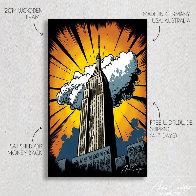 May include: A pop art style print of the Empire State Building against a yellow and orange background. The artwork features the building in black and white with a cloud and the artist's signature. The print is framed with a 2cm wooden frame.