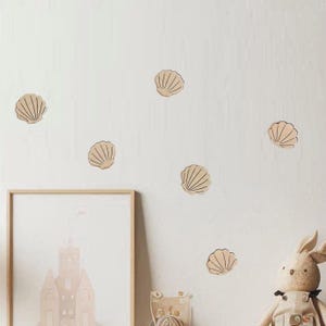 There are seashell-shaped decorations stuck to the wall. The seashells are made of wood.