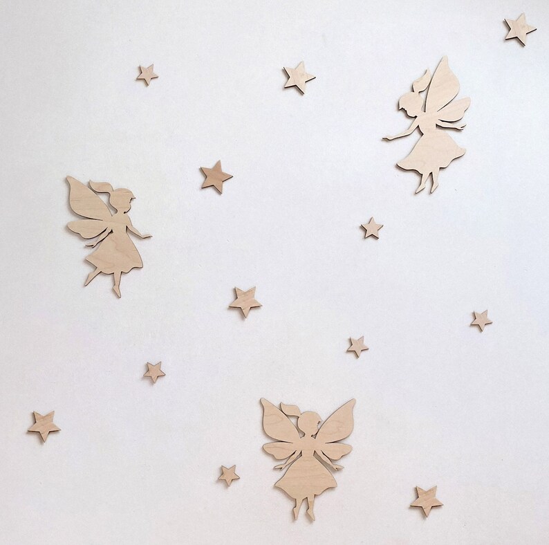 May include: A set of wooden fairy and star wall decor. The fairies are in a flying pose with wings outstretched. The stars are five-pointed and scattered around the fairies.