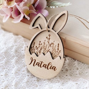 May include: Wooden Easter egg ornament with bunny ears, featuring a floral design and the name "Natalia" engraved on the front.