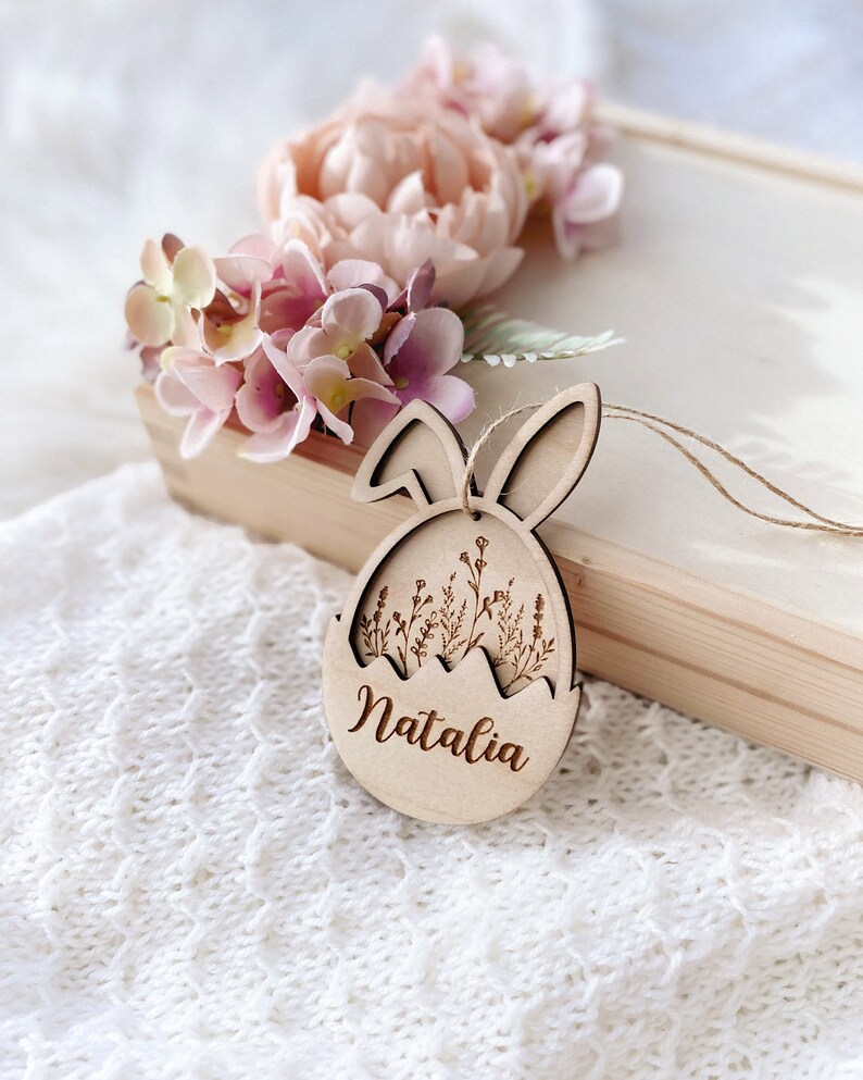 May include: Wooden Easter egg ornament with bunny ears, featuring a floral design and the name "Natalia" engraved on the front.