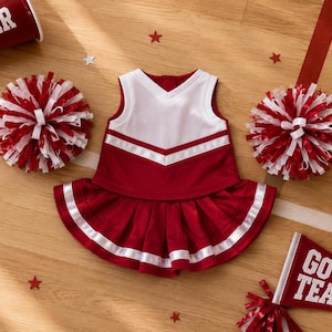 May include: A maroon and white sleeveless cheerleading uniform consisting of a V-neck top and a pleated skirt with white trim. The set includes two matching maroon and white pom-poms, a maroon megaphone with the text CHEER, and a maroon pennant with GO TEAM.