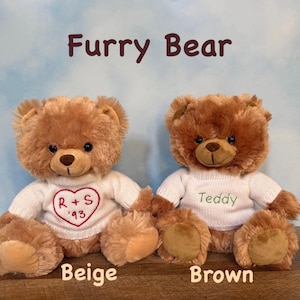 May include: Two plush teddy bears, one beige and one brown, are displayed. Each bear wears a white sweater. The beige bear's sweater has a red heart with "R + S '93". The brown bear's sweater says "Teddy". The text "Furry Bear" is above the bears.