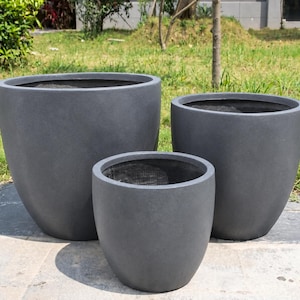 May include: A set of three dark grey, smooth, rounded planters of varying sizes. Each planter features a wide, open top and a tapered base, creating a consistent, uniform appearance across the collection for holding plants or decorative items.