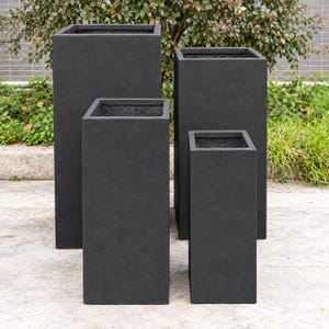 May include: A set of four tall, rectangular planters with a matte black finish. The planters are arranged in a staggered formation, featuring clean, sharp edges and a uniform, textured surface on all visible sides of the containers.