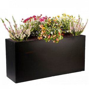 May include: A rectangular black planter box filled with a variety of colourful flowers and greenery. The flowers include pink, yellow, and red blooms, with green foliage and berries. The planter is made of a dark material.