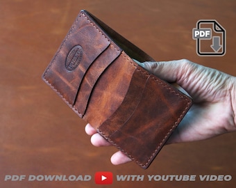 May include: A brown leather wallet with multiple card slots and a stitched edge. The wallet is held in a hand.