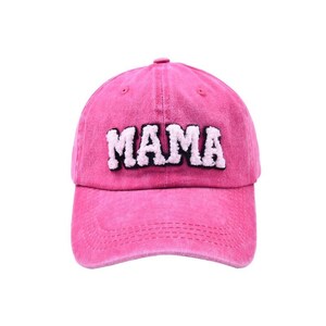 May include: Pink baseball cap with the word "MAMA" in white fluffy letters with black outlines.