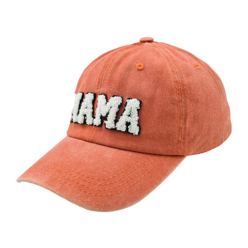May include: A bright orange baseball cap with the word "MAMA" embroidered in white with black outlines.