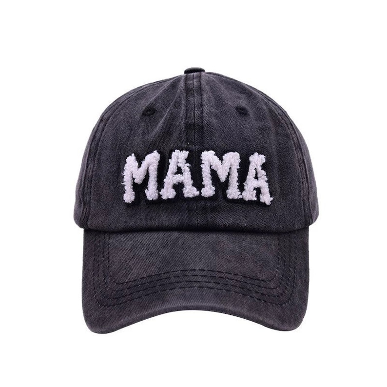 May include: A black denim baseball cap with a white fuzzy "MAMA" embroidered on the front.