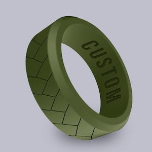 May include: A green silicone ring with a textured pattern and the word "CUSTOM" engraved on the side.