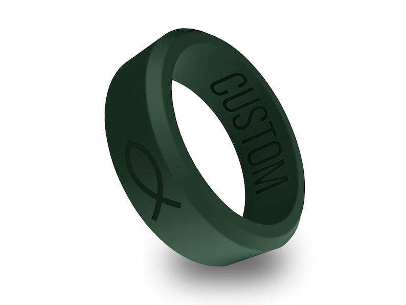 以下が含まれることがあります： 側面に「CUSTOM」と刻印され、反対側に魚の形の刻印が施された濃い緑色のシリコンリングです。