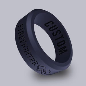 May include: A dark blue silicone ring with the words "FIREFIGHTER" and "CUSTOM" engraved on it. The ring also features a small axe graphic.