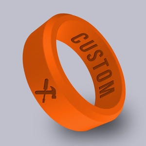 May include: Orange silicone ring with the word "CUSTOM" engraved on the side and a hammer and screwdriver symbol engraved on the other side.