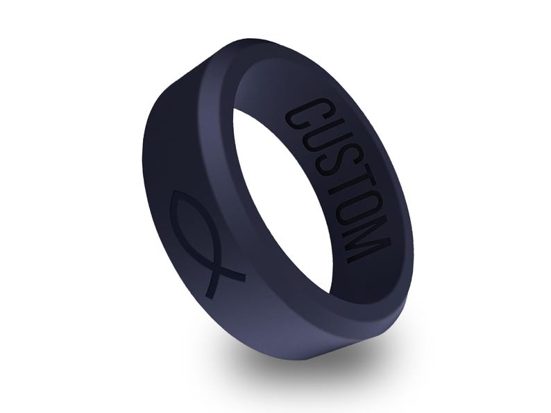 以下が含まれることがあります： 片側に「CUSTOM」と刻まれた、濃い青色のシリコンリング。反対側には魚のシンボルが刻まれています。