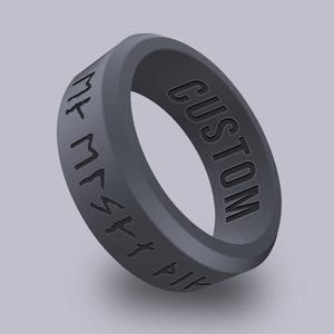 May include: A black silicone ring with the word "CUSTOM" engraved on one side and the text "VIK M154K" engraved on the other side.