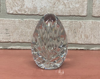 May include: A clear glass paperweight in the shape of an egg with a cut-glass design.