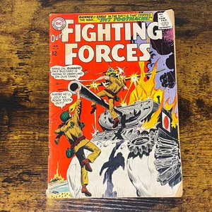 May include: A vintage comic book cover featuring a red, white, and blue illustration of a tank with a soldier hanging on to the side. The comic book is titled "Our Fighting Forces" with the text "Gunner & Sarge in the battle that stopped the war..." at the top.