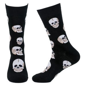 May include: Black socks with a repeating pattern of white and tan skulls. The socks are knee-high and made of a soft material. The skulls are detailed with eye sockets, noses, and teeth.