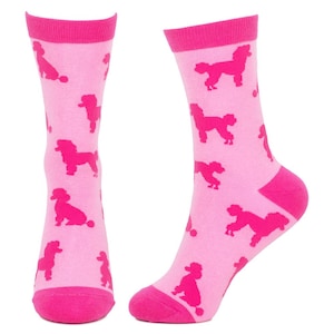 May include: A pair of pink socks featuring a repeating pattern of fuchsia poodle silhouettes. The socks have fuchsia heels, toes, and cuffs. The poodle illustrations are in various poses.