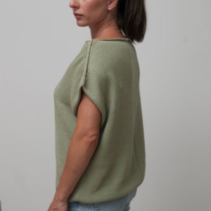 Puede incluir: Una camiseta de punto verde salvia con mangas cortas y cuello redondo.