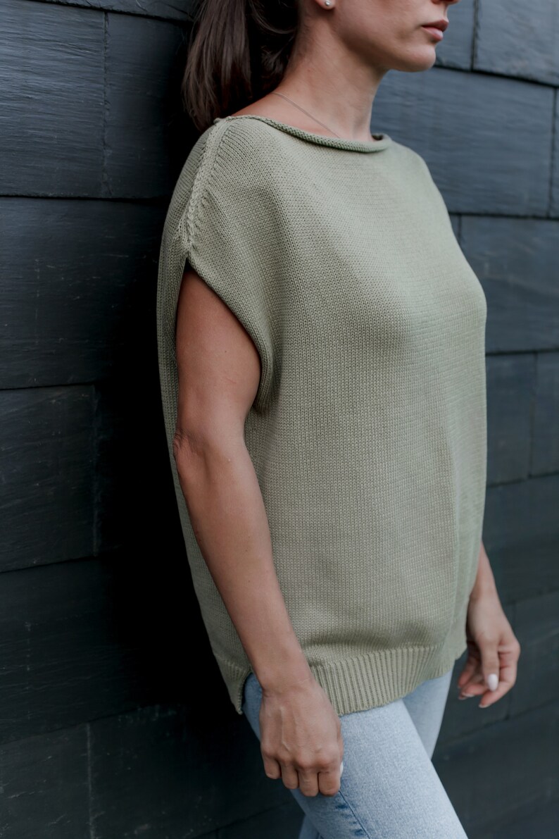 Puede incluir: Un top de punto verde claro con mangas cortas y cuello de barco. El top est&aacute; hecho de una tela suave y ligera y tiene un ajuste holgado.
