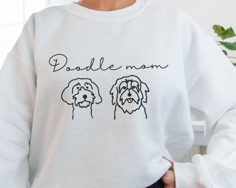 Może przedstawiać: Biała bluza z napisem "Doodle mom" i dwoma ilustracjami psów pudli.