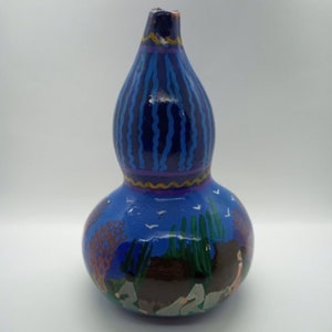 May include: Hand-painted gourd vase with a blue and purple base, a blue and white scene with birds and trees, and a brown and white scene with people in the bottom half.