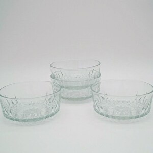 May include: Set of four clear glass bowls with a textured design. The bowls are stacked on top of each other.