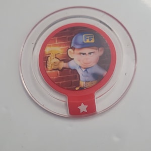 May include: A red and white plastic game piece with a cartoon character holding a hammer. The character is wearing a blue hat with the letters "FF" on it. The game piece has a star on the bottom.