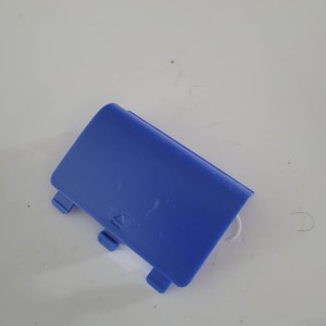 May include: A blue plastic battery cover with a small arrow pointing upwards.