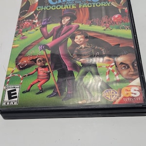 May include: A PlayStation 2 video game case featuring a colorful illustration of characters from the movie "Charlie and the Chocolate Factory". The game is rated "E" for Everyone by the ESRB.