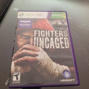 May include: Xbox 360 video game case with a purple border. The game is called "Fighters Uncaged" and features a close-up of a man's fist with bandages. The game requires a Kinect sensor. The game is rated T for Teen by the ESRB. The game is published by Ubisoft.
