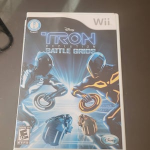 May include: A white Nintendo Wii game case with a blue and orange Tron: Evolution Battle Grids game cover. The cover features two characters in futuristic suits riding light cycles on a glowing track.