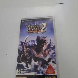 May include: A Monster Hunter Portable 2nd video game case for the PlayStation Portable (PSP) console. The case features a blue and brown monster with a white background. The game is rated G by the ESRB. The text on the case reads "Monster Hunter Portable 2nd".