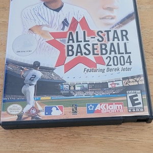May include: A Nintendo GameCube game case for All-Star Baseball 2004, featuring Derek Jeter. The cover art shows a baseball player in a Yankees uniform and the game's title in red and white. The game is rated "E" for Everyone.