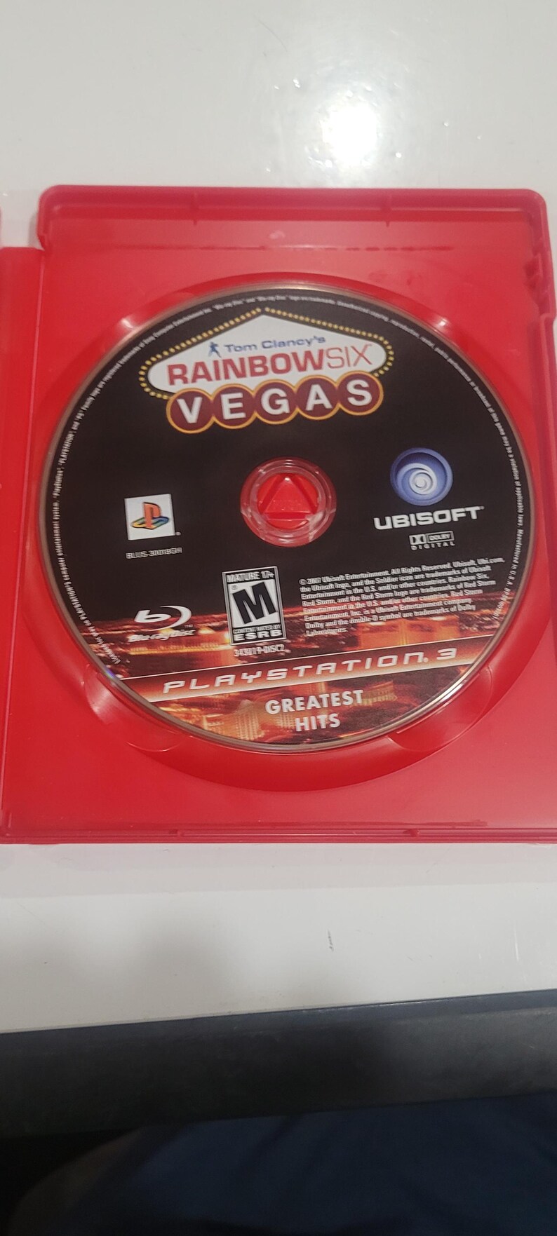 Puede incluir: Un disco de juego de PlayStation 3 para Tom Clancy's Rainbow Six Vegas, en una caja roja. El disco es negro con el t&iacute;tulo del juego en dorado y rojo. El juego est&aacute; clasificado M para Mature.