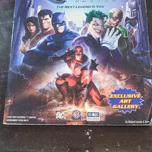 May include: DC Universe Online official strategy guide by BradyGames. The cover features a collage of DC Comics characters, including Batman, Superman, and The Joker. The guide covers the Sony Playstation 3, computer entertainment system, and PC.