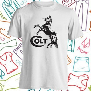 以下が含まれることがあります： 白地に黒と白の馬が立ち上がっているグラフィックと「COLT」の文字が前面に印刷されたTシャツです。