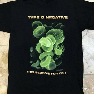 May include: Black t-shirt with a green graphic of cells and the text "Type O Negative" and "This Blood's For You".