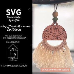 以下が含まれることがあります： 花柄のピンクと白のマクラメ製の車のチャーム。チャームは車のリアビューミラーに吊り下げられています。画像の下部に「デザインをコピーまたは変更しないでください」というテキストが表示されています。