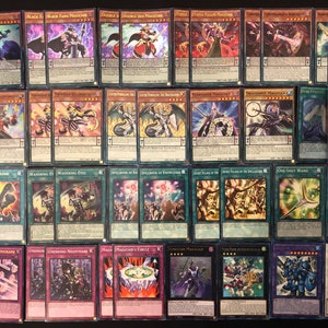 Può includere: Una collezione di 24 carte collezionabili con varie illustrazioni di creature e personaggi magici. Le carte sono disposte in quattro file di sei carte ciascuna. Le carte sono tutte in buone condizioni e hanno una varietà di colori e disegni.