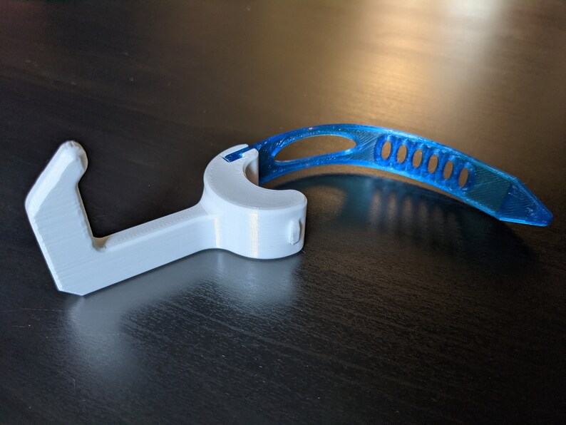 Puede incluir: Un gancho de pl&aacute;stico blanco con una correa de pl&aacute;stico azul. El gancho est&aacute; dise&ntilde;ado para ayudar a abrir puertas y otras superficies sin tocarlas.