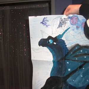 May include: A hand-drawn illustration of a blue dragon with a starry wing design, set against a backdrop of a moon and other flying creatures. The dragon has blue eyes and a horn. The artwork is on white paper.