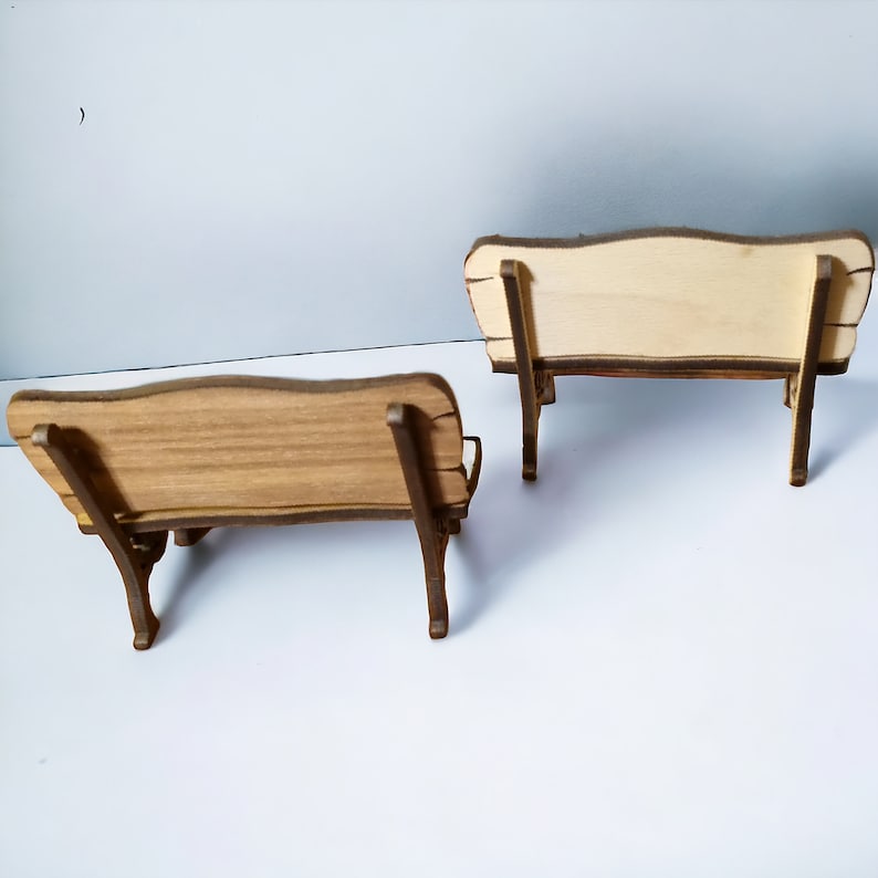 K&ouml;nnte beinhalten: Zwei Holzb&auml;nke mit einfachem Design. Die B&auml;nke sind aus hellbraunem Holz gefertigt und haben eine leicht geschwungene R&uuml;ckenlehne.