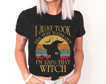 May include: Black t-shirt with a vintage-style graphic that says "I Just Took a DNA Test Turns Out I'm 100% That Witch". The graphic features a silhouette of a witch with a hat and a crescent moon.