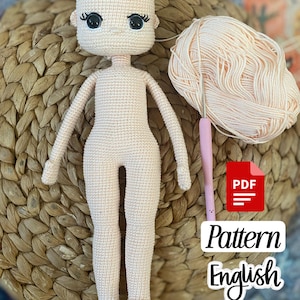 May include: A crocheted doll in a light peach color, with black embroidered eyelashes and eyes. A ball of peach yarn and a pink crochet hook are next to the doll. The image includes a PDF icon with the words "Pattern English".
