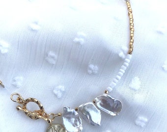 Natural mother-of-pearl, quartz, shell and gold-plated pearl necklace. Gold-plated baton closure.