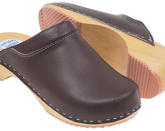 May include: Pair of brown leather clogs with wooden soles and pink rubber treads. The clogs have a rounded toe and are stitched with white thread. The words "NATURAL LEATHER" are printed on the insole.